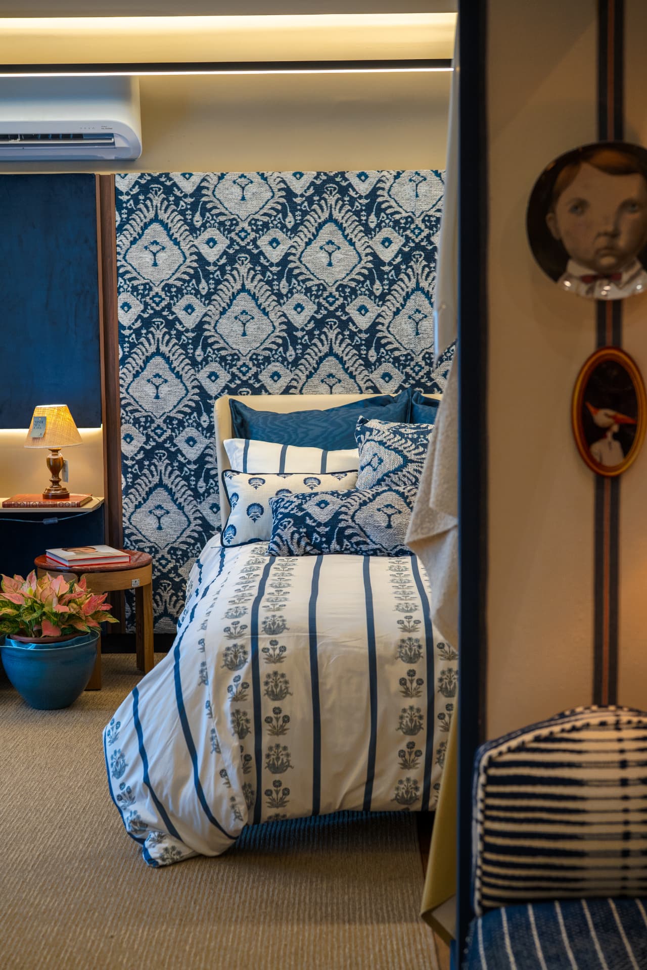 Quarto em azul e branco com roupa de cama estampada e criado-mudo de vime · Luize Home